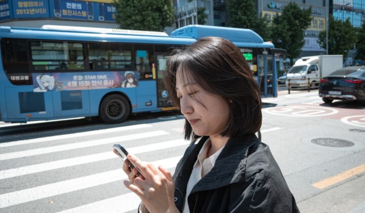 Person using a smartphone on a street in South Korea