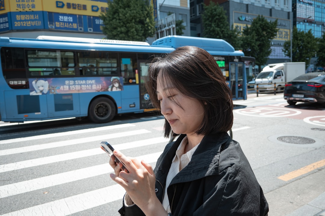 Person using a smartphone on a street in South Korea